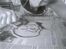 Titi rolt een linoplaat, een zelfportret, in met inkt